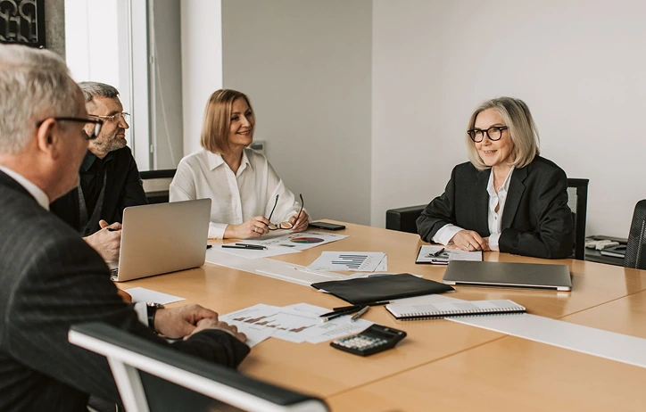 People in suits meeting at a conference table.
